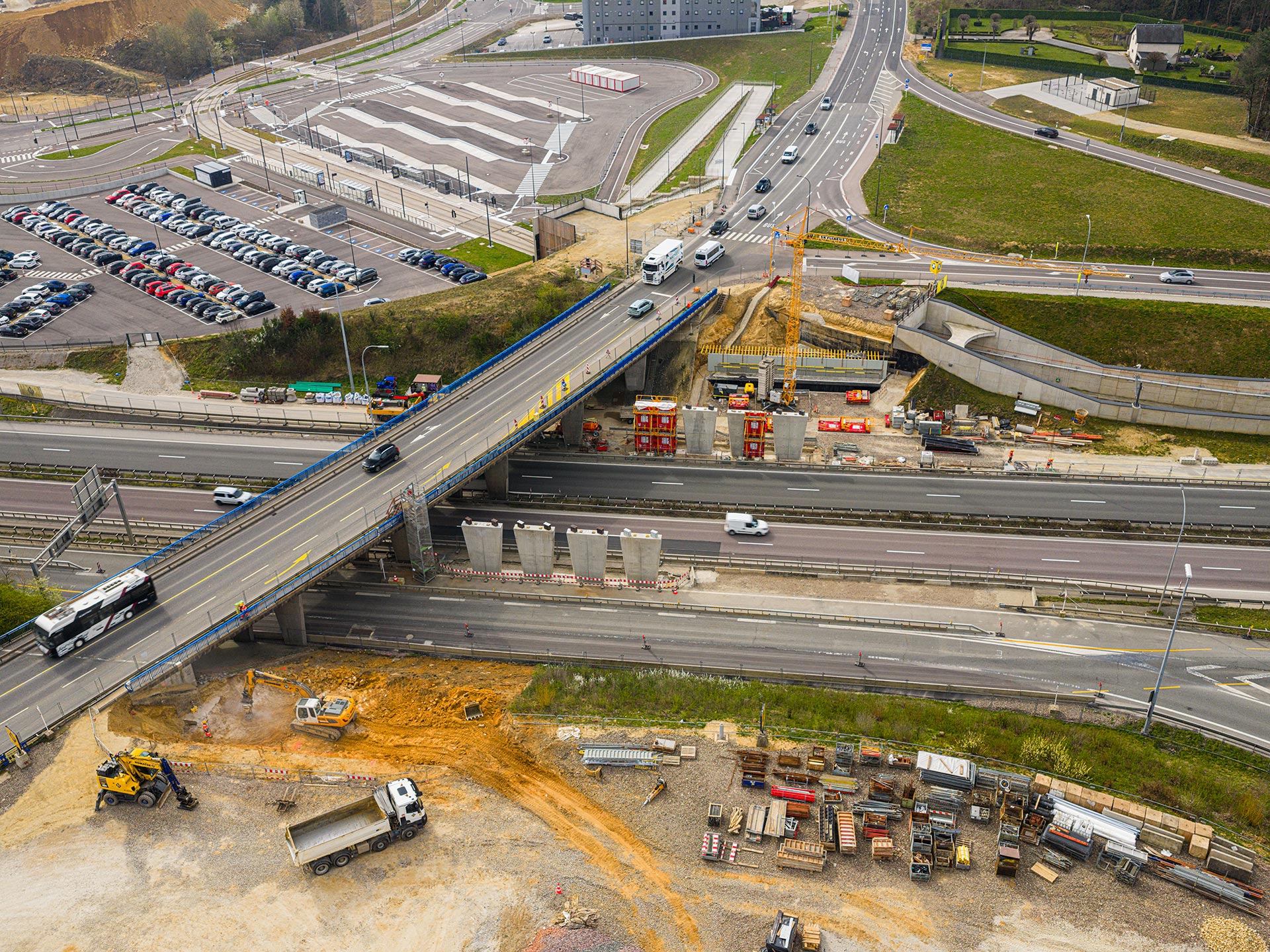 Vue aérienne du chantier du nouveau pont sur l'autoroute A1 au Findel, montrant huit piles en béton à côté du pont existant.